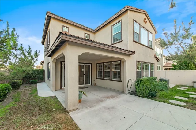 a view of a patio with a table and chairs under an umbrella with a garden