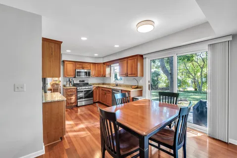 a kitchen with a table chairs refrigerator and cabinets