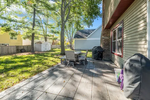 a view of backyard with table and chairs and a large tree
