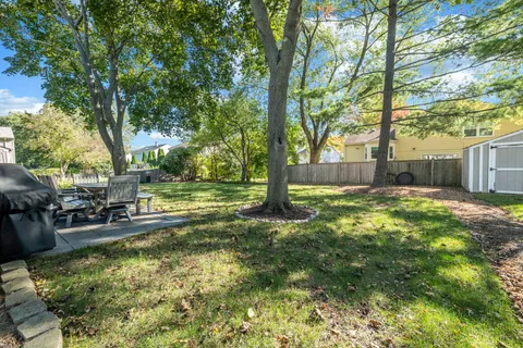 a backyard of a house with fountain table and chairs