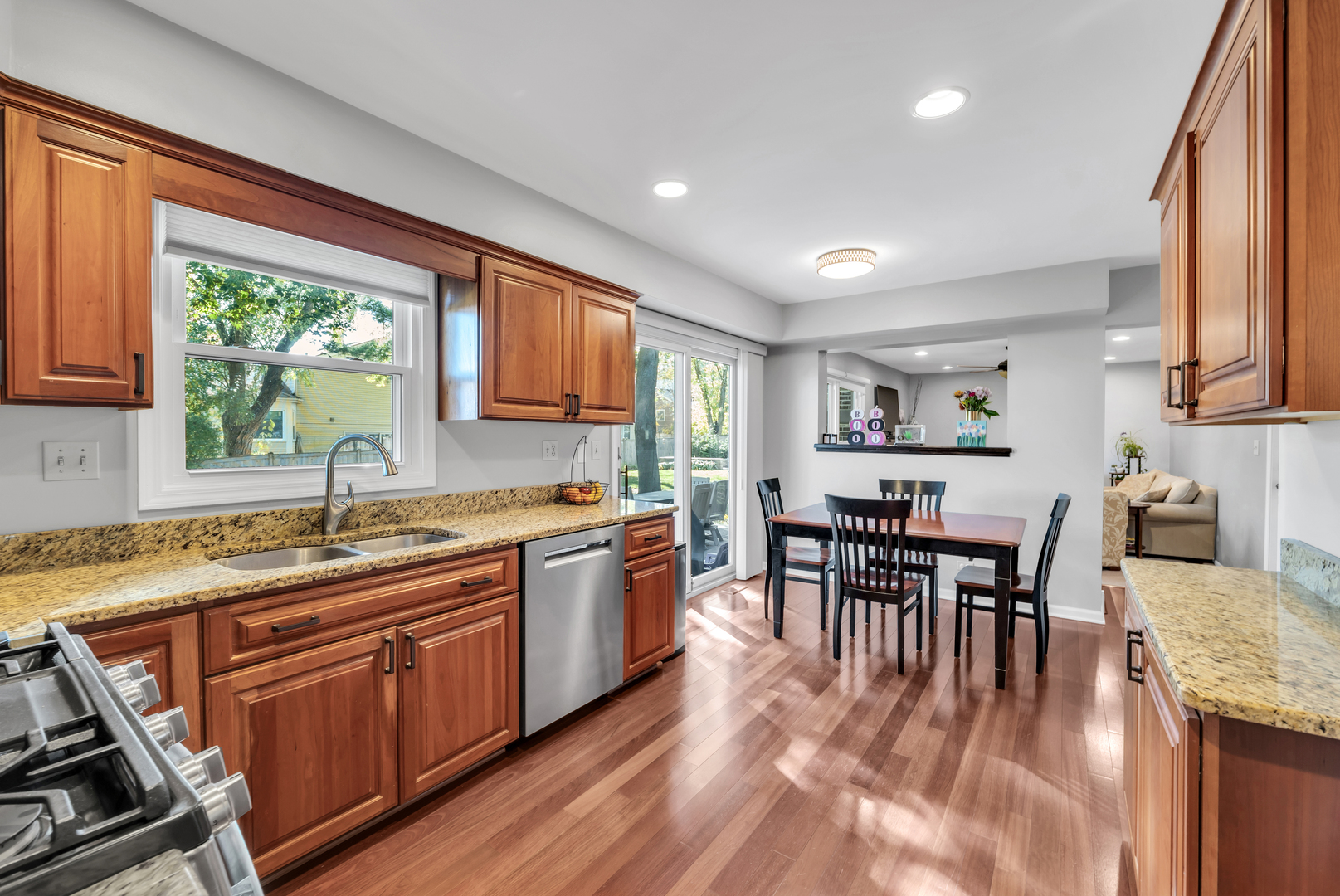 896 Chaucer Way Buffalo Grove, IL 60089 - Photo 9 of 26 a kitchen with kitchen island granite countertop wooden floors and wooden cabinets