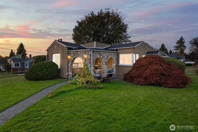 a view of a house with a big yard plants and large trees