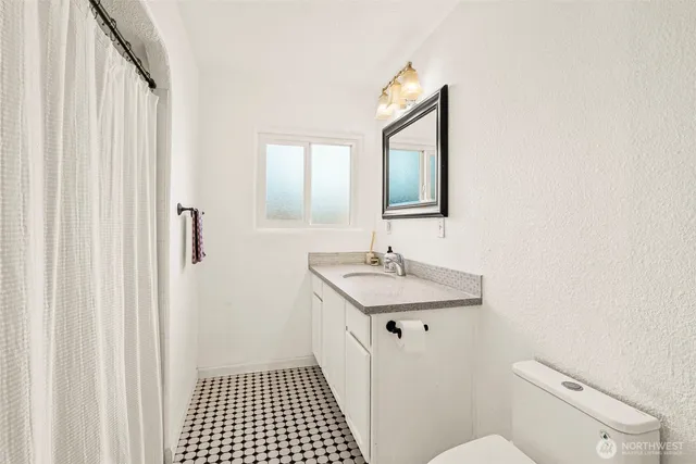 a bathroom with a sink a toilet and a mirror