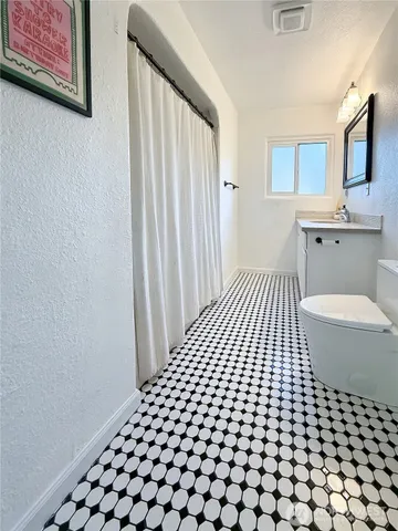 a bathroom with a black white checkered floor