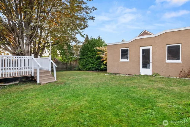 a view of a house with a yard and deck