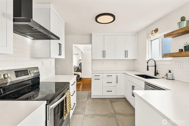 a kitchen with granite countertop a sink stove and refrigerator