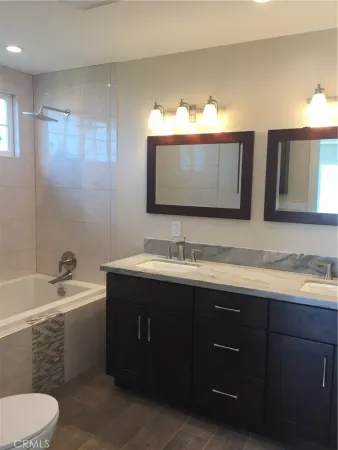 a bathroom with a granite countertop sink a toilet and a bathtub