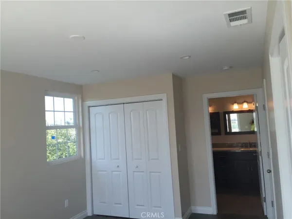 an empty room with windows and closet