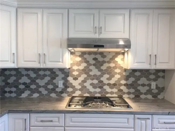 a kitchen with granite countertop white cabinets and a stove