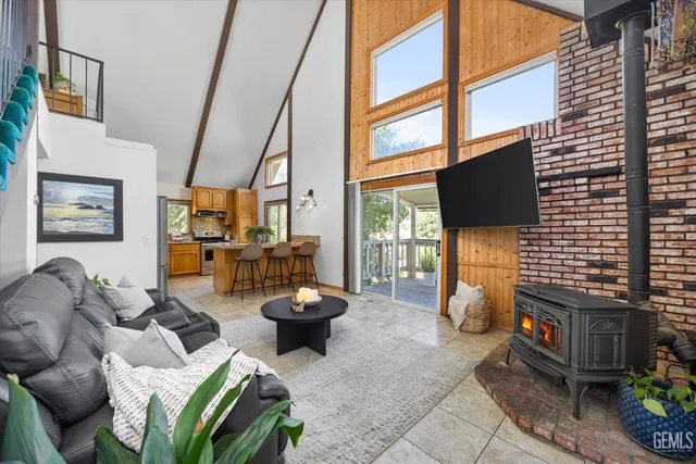 a living room with furniture a flat screen tv and a floor to ceiling window