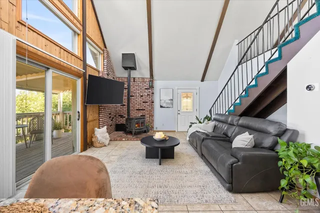 a living room with furniture a flat screen tv and a large window
