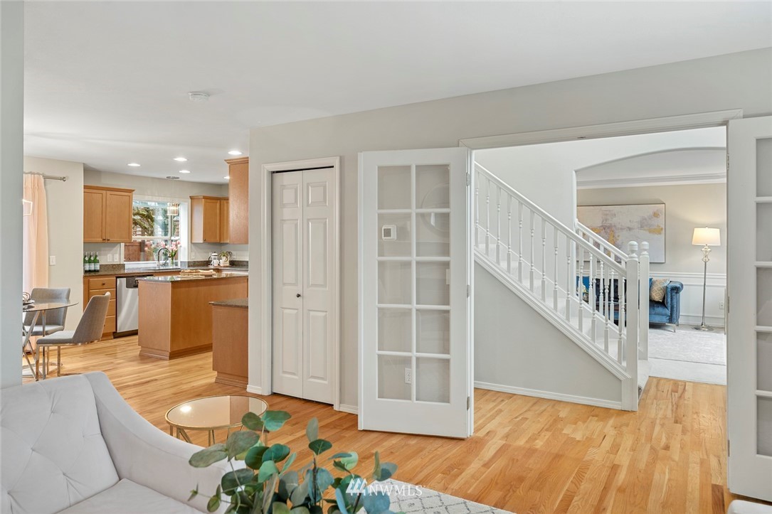 5112 Northeast 20th Street Renton, WA 98059 - Photo 20 of 40 a view of a living room and kitchen with furniture wooden floor and windows