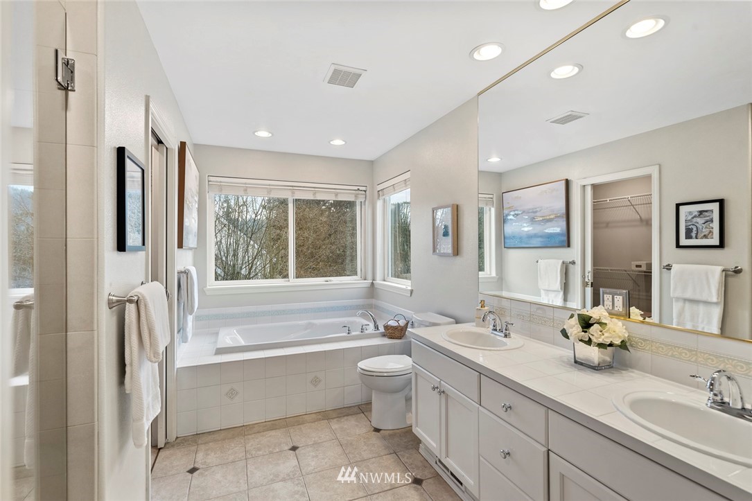 5112 Northeast 20th Street Renton, WA 98059 - Photo 30 of 40 a bathroom with a double vanity sink toilet mirror and bathtub