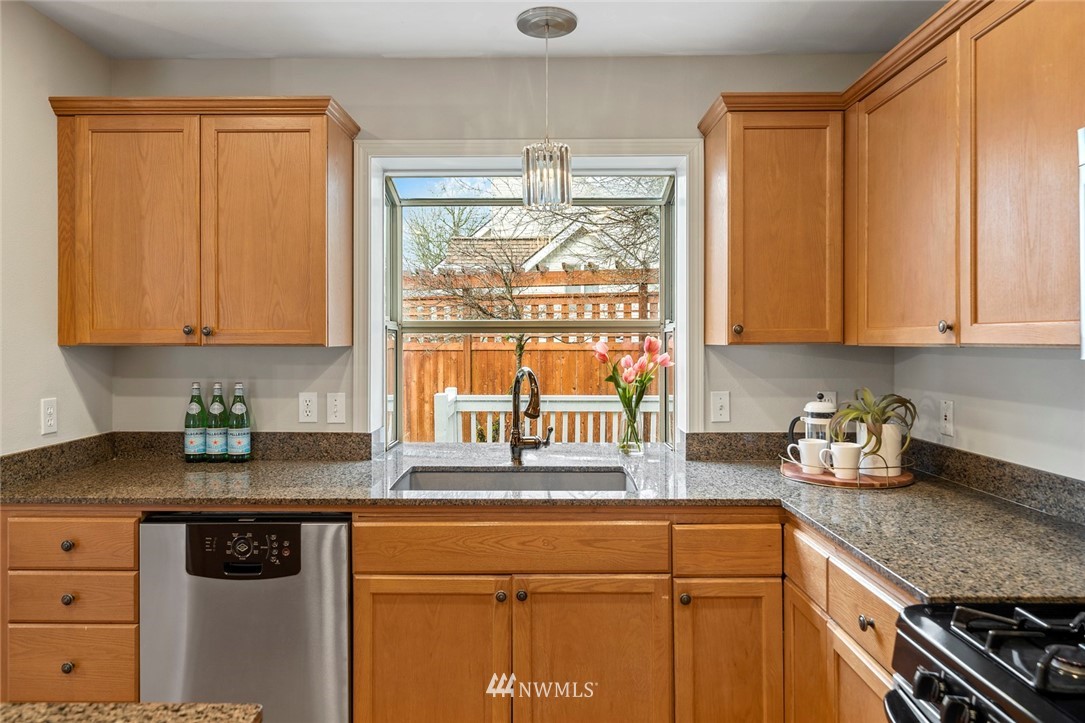 5112 Northeast 20th Street Renton, WA 98059 - Photo 10 of 40 a kitchen with stainless steel appliances granite countertop a sink a stove and a microwave