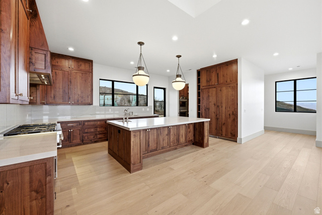 2155 East Wrangler Road Kamas, UT 84036 - Photo 11 of 62 Kitchen featuring tasteful backsplash, a large island, light wood finished floors, hanging light fixtures, and light stone countertops