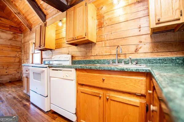 a kitchen with wooden floors and white appliances
