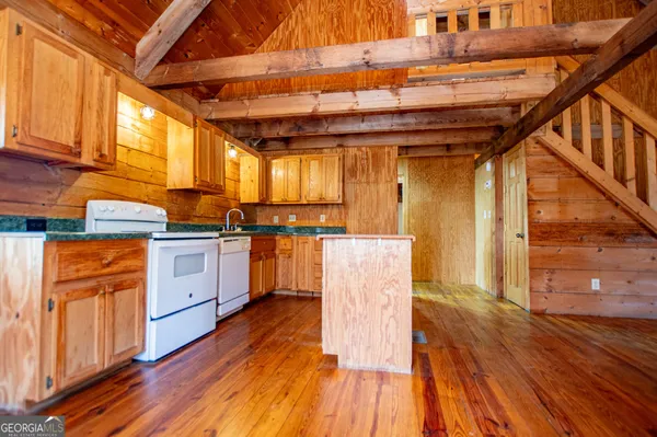 a view of a kitchen with stainless steel appliances granite countertop a stove and cabinets