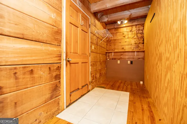 a view of an empty room with wooden floor and a stairs
