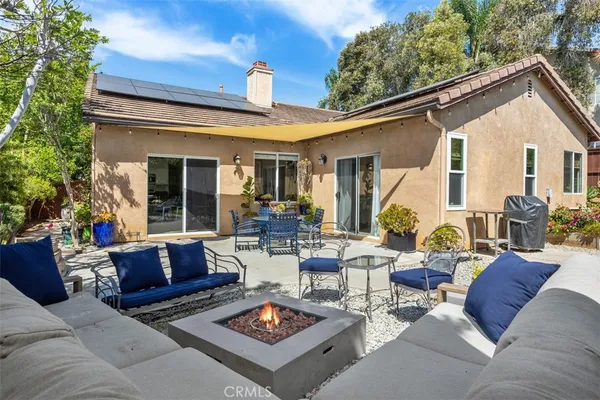 a view of a patio with couches table and chairs with wooden floor and fence and a potted plant