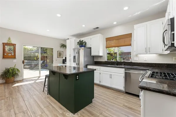 a kitchen with granite countertop a sink stove and cabinets