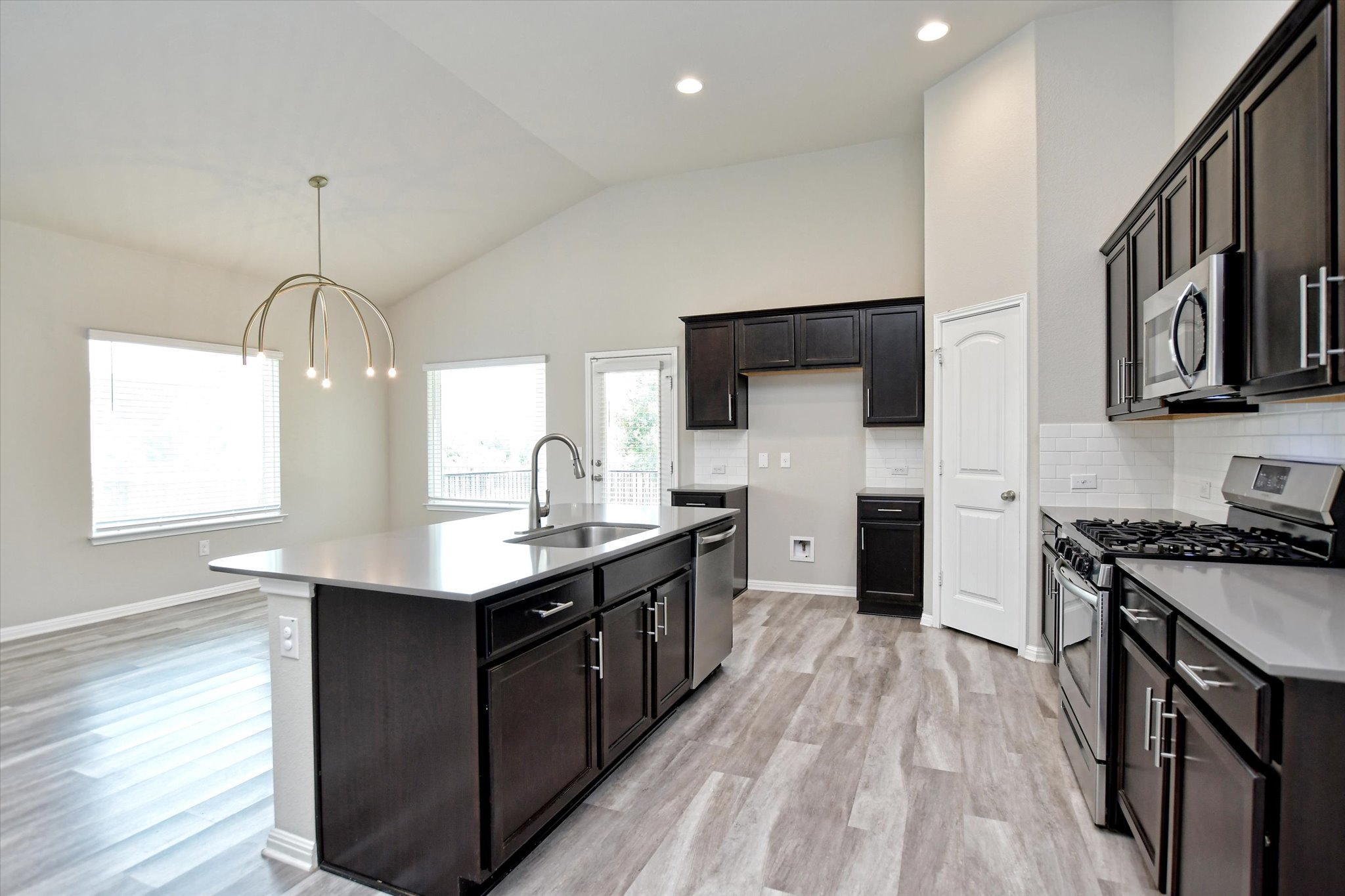 4300 Porter Farm Road Georgetown, TX 78628 - Photo 11 of 36 A contemporary kitchen and dining space with vaulted ceilings and abundant natural light.