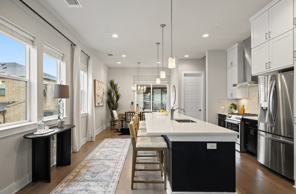 3900 Sightline Street, Unit 127 Austin, TX 78731 - Photo 20 of 39 a kitchen with stainless steel appliances kitchen island granite countertop a refrigerator a sink a stove and white cabinets with wooden floor