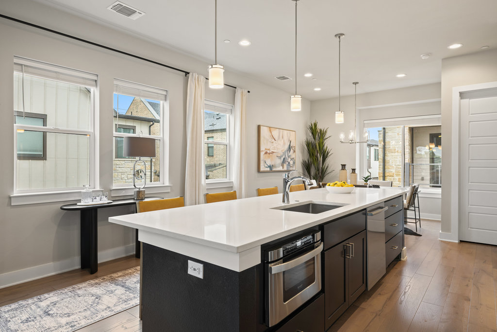 3900 Sightline Street, Unit 127 Austin, TX 78731 - Photo 21 of 39 a kitchen with stainless steel appliances granite countertop a sink and a wooden floor