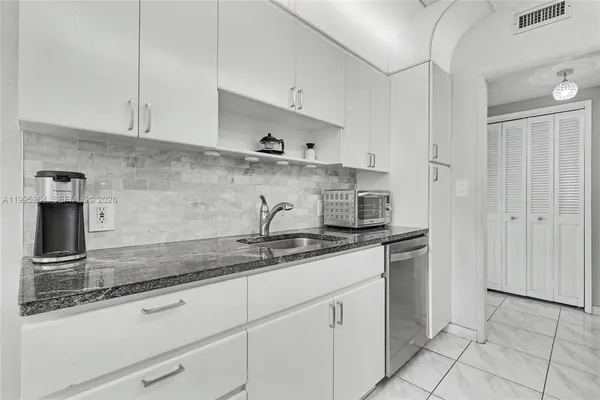 a kitchen with cabinets stainless steel appliances and a counter space