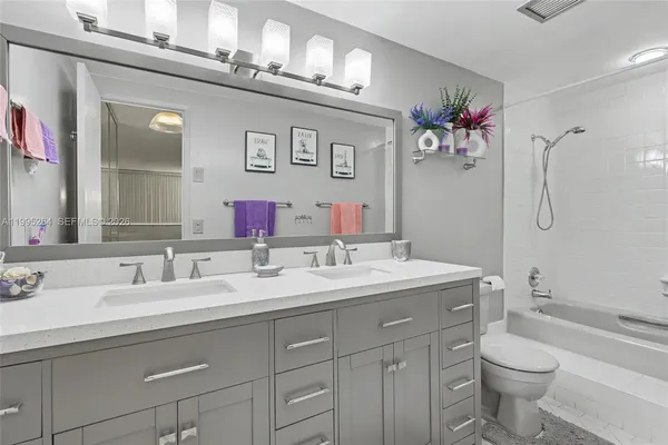 a bathroom with a sink vanity mirror and toilet