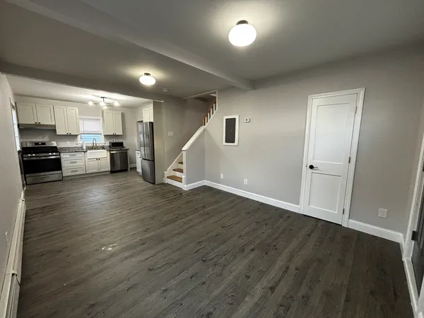 an empty room with wooden floor and a window