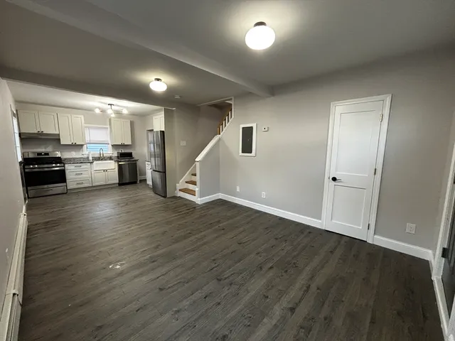 an empty room with wooden floor and a window
