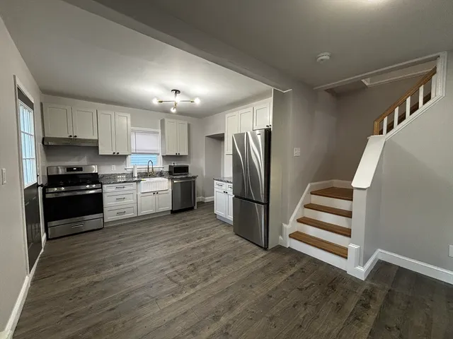 a kitchen with a refrigerator cabinets and wooden floor