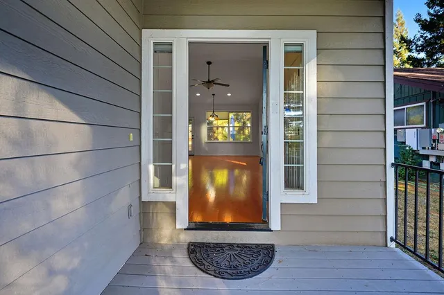 a view of an empty room with a window and wooden floor