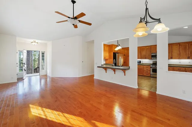 a kitchen with stainless steel appliances a refrigerator and a wooden floor