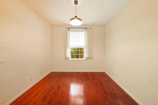 a view of a room with wooden floor and windows