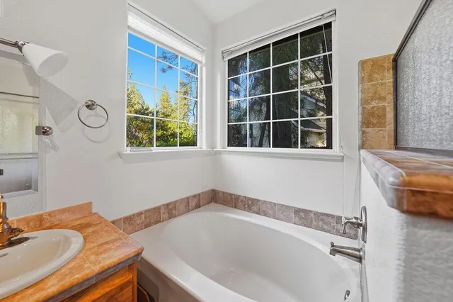 a bathroom with a tub sink and a window
