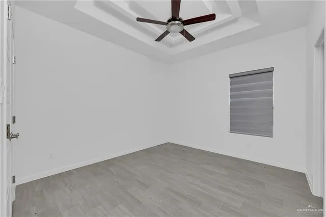 an empty room with a ceiling fan and a window