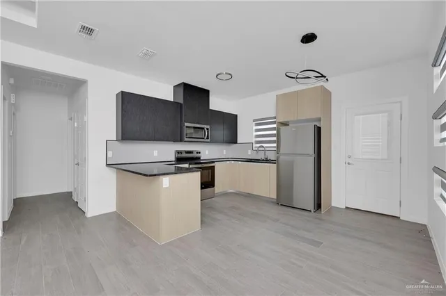 a kitchen with stainless steel appliances a refrigerator and a stove top oven