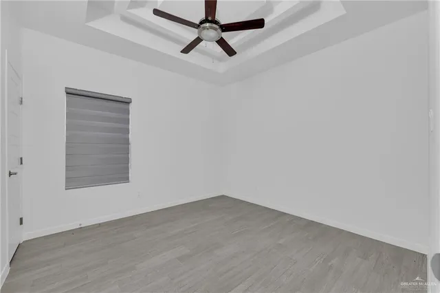 an empty room with a window and a ceiling fan