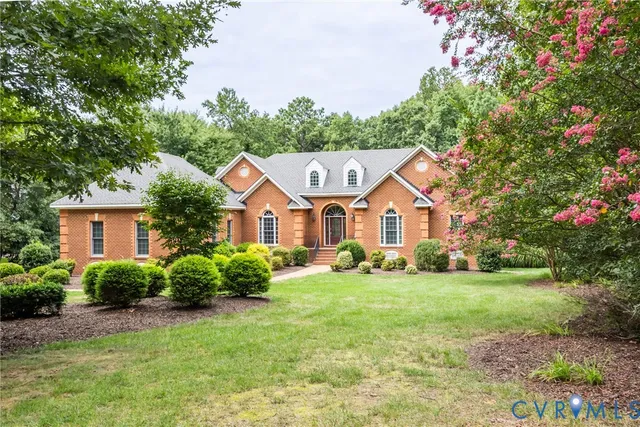 a view of a house with a big yard and large trees