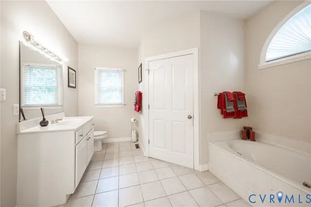 a bathroom with a sink toilet vanity and tub