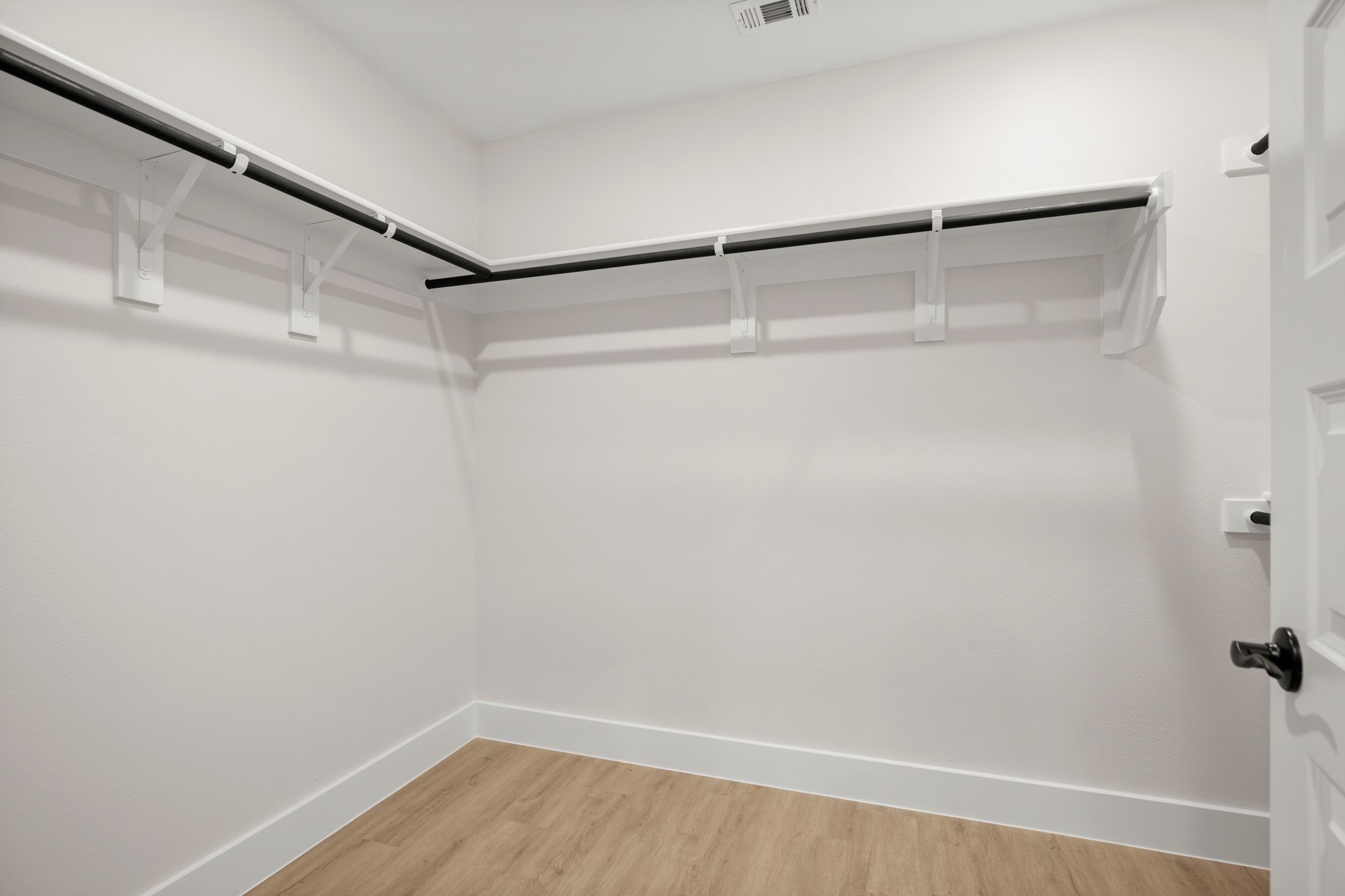 5502 Mobeetie Loop Bee Cave, TX 78738 - Photo 7 of 16 Walk-in closet featuring light wood-finish flooring, white baseboards, and white walls