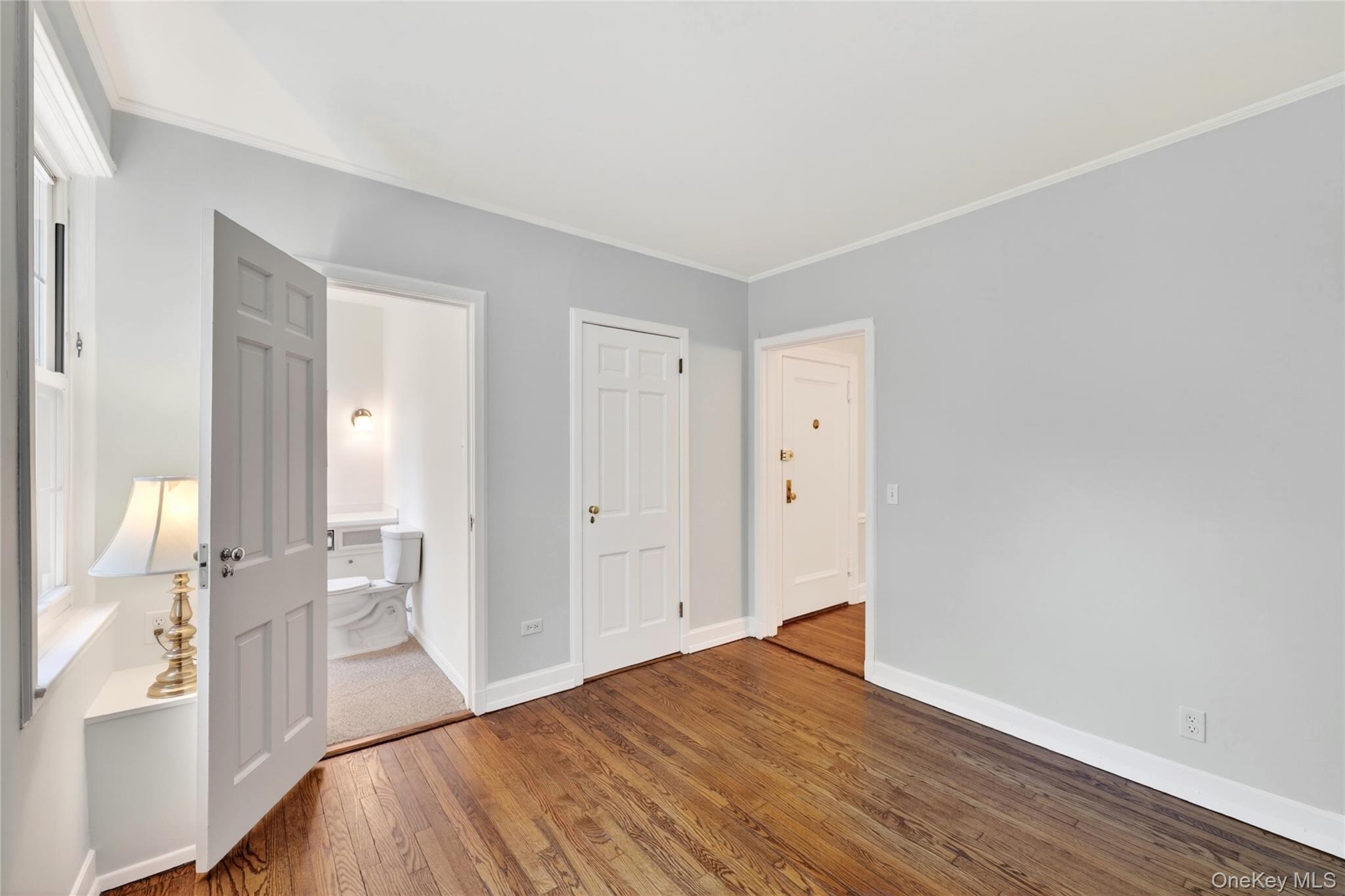 10 Brooklands, Unit 5H Bronxville, NY 10708 - Photo 5 of 33 Alternate view of Bedroom #1 with view of the powder room and closet with custom shelving