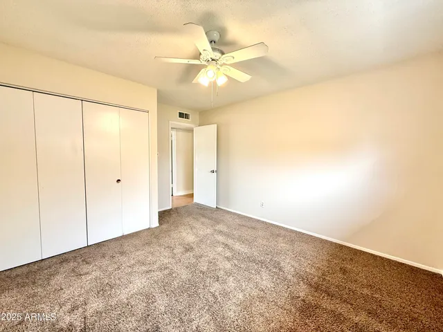 an empty room with a fan and a ceiling fan