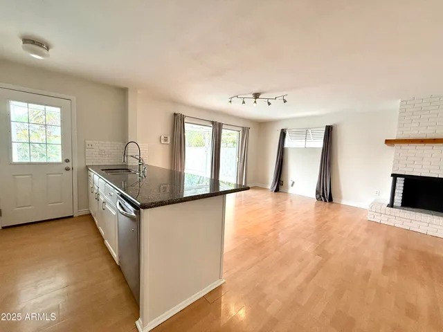 a kitchen with granite countertop a sink and a stove top oven
