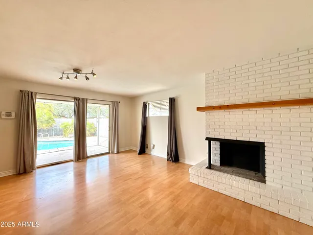 a view of an empty room with a fireplace and a window