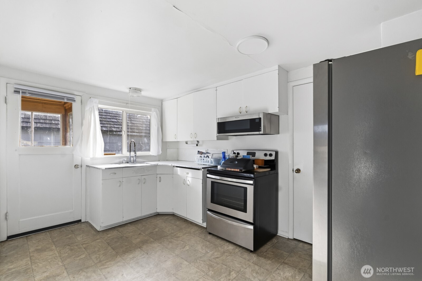 205 Jefferson Street Hoquiam, WA 98550 - Photo 13 of 21 a kitchen with stainless steel appliances granite countertop a refrigerator and a stove top oven