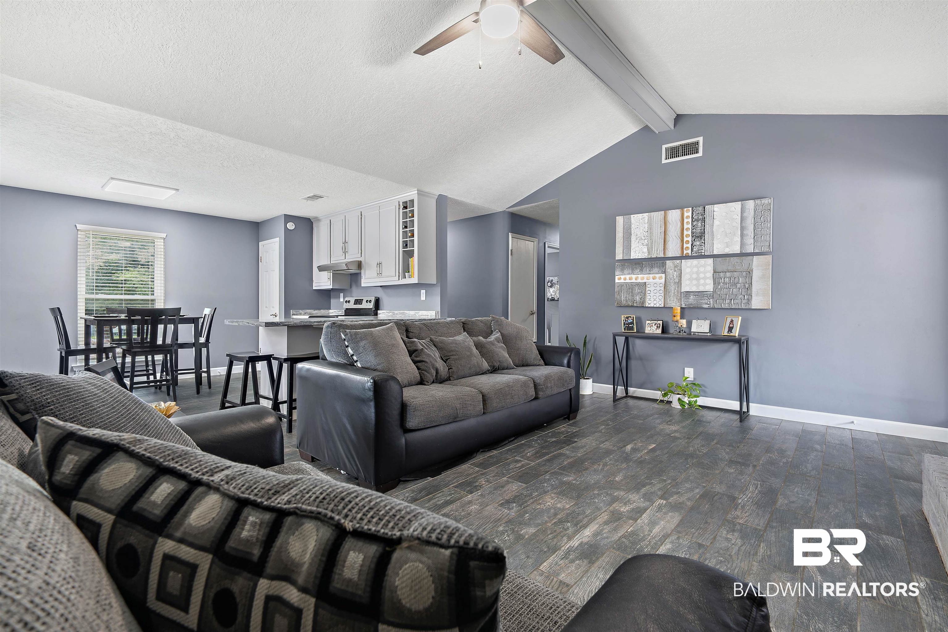 2000 Campfire Drive Semmes, AL 36575 - Photo 7 of 26 Living room with dark wood-type flooring, vaulted ceiling with beams, and ceiling fan