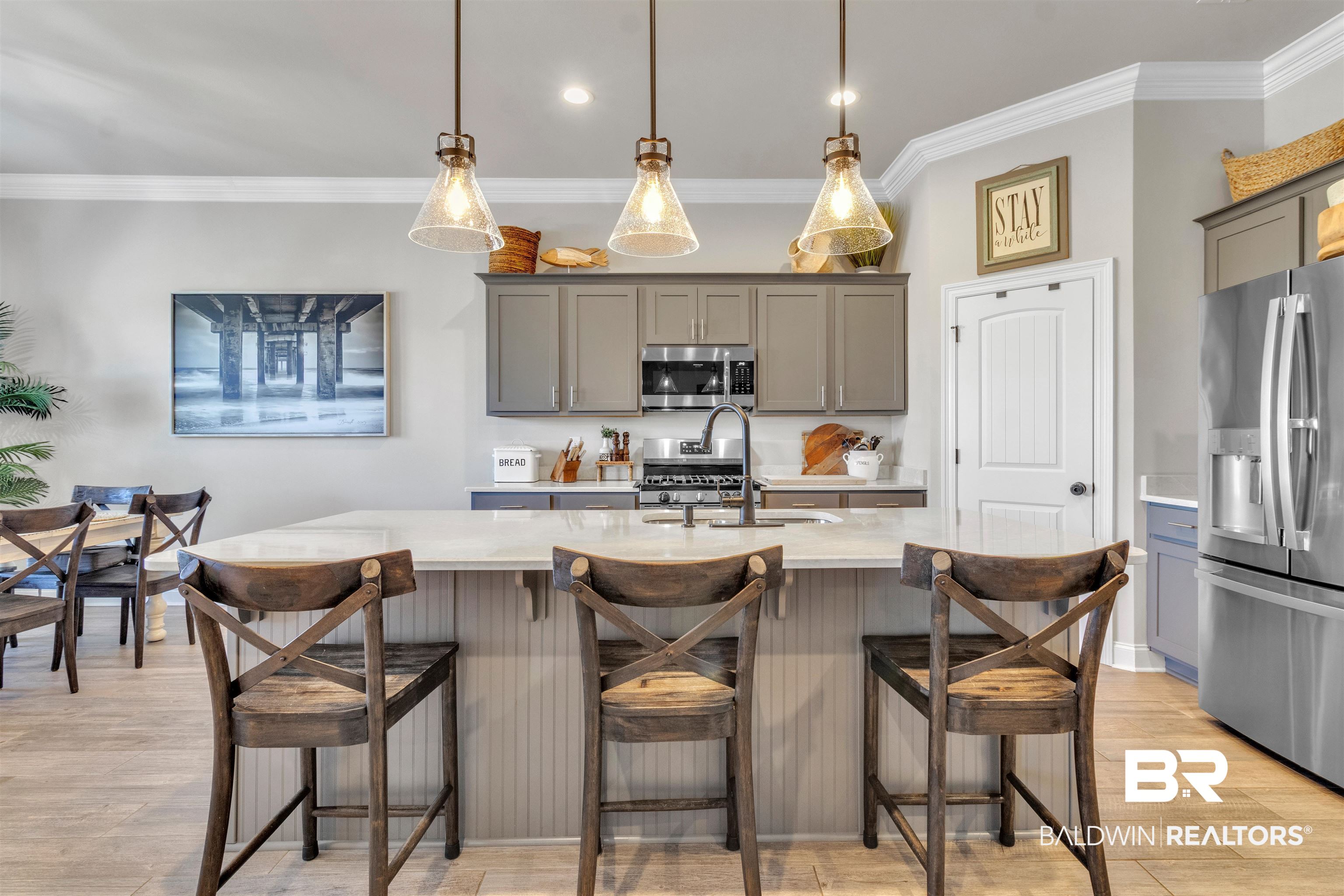 22531 Putter Lane Foley, AL 36535 - Photo 10 of 43 Kitchen featuring gray cabinets, stainless steel appliances, decorative light fixtures, a kitchen island with sink, and crown molding