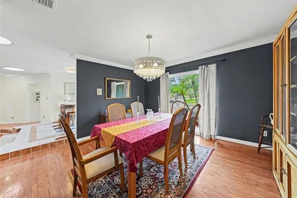 a dining room with furniture a chandelier and wooden floor